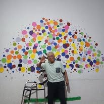 Residente frente a mural de colores